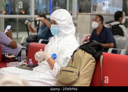 COSTA D'AVORIO, Abidjan, aeroporto, viaggiatore cinese con abbigliamento di protezione durante Corona Pandemic tempo al cancello sul volo per Parigi / ELFENBEINKÜSTE, Abidjan, Flughafen, Chinesische Reisende in Schutzkleidung während der Corona Pandemie Foto Stock