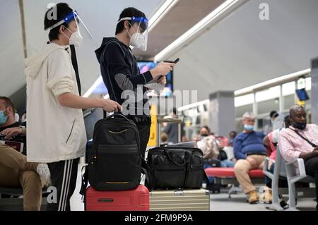 COSTA D'AVORIO, Abidjan, aeroporto, viaggiatore cinese con abbigliamento di protezione durante Corona Pandemic tempo al cancello sul volo per Parigi / ELFENBEINKÜSTE, Abidjan, Flughafen, Chinesische Reisende in Schutzkleidung während der Corona Pandemie Foto Stock