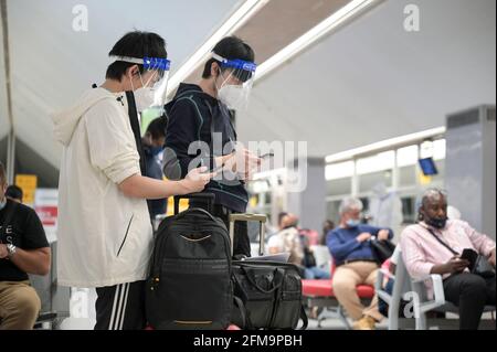 COSTA D'AVORIO, Abidjan, aeroporto, viaggiatore cinese con abbigliamento di protezione durante Corona Pandemic tempo al cancello sul volo per Parigi / ELFENBEINKÜSTE, Abidjan, Flughafen, Chinesische Reisende in Schutzkleidung während der Corona Pandemie Foto Stock