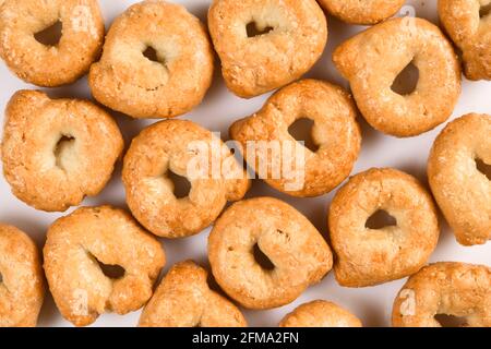 Taralli o tarallini, tradizionale spuntino di italin da pasta di grano. Sfondo di alcuni pezzi closeup isolato su bianco. Foto Stock