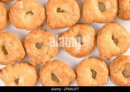 Taralli o tarallini, tradizionale spuntino di italin da pasta di grano. Sfondo di alcuni pezzi closeup isolato su bianco. Foto Stock