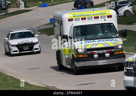 I veicoli di emergenza, la polizia e l'ambulanza (London EMS) bloccano una strada che risponde a una chiamata a Londra, Ontario, Canada. Foto Stock