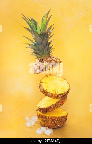 Flying fresco ananas mature fette isolate su sfondo giallo. Messa a fuoco selettiva, spazio di copia Foto Stock