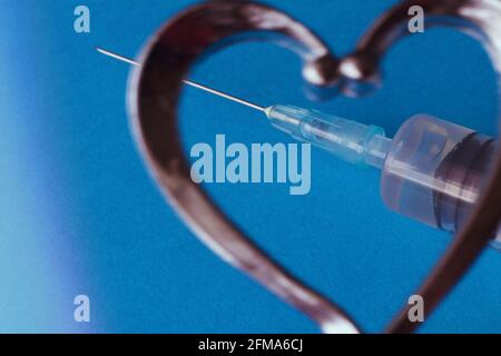 Primo piano di una siringa a forma di cuore . Foto Stock