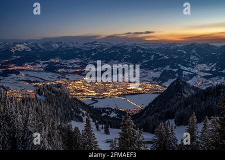 Sonthofen, illuminato al tramonto in una fredda serata invernale, visto dal Grünten. Incorniciato dalle Alpi Allgäu innevate sotto un cielo blu. Baviera, Germania, Europa Foto Stock