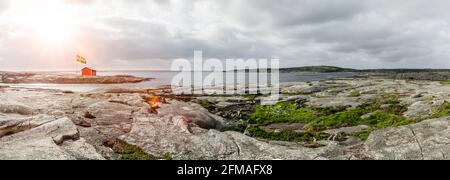 Casa rossa con bandiera sull'arcipelago svedese Foto Stock