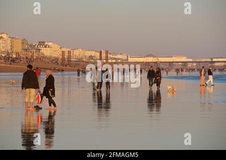 I beachgoers sulla spiaggia di Brighton durante una bassa marea, nel tardo pomeriggio, in primavera. Brighton, Susse, Inghilterra Foto Stock