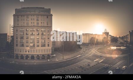 Alba dietro la fontana di Strausberger Platz di Berlino con le torri del Frankfurter Tor sullo sfondo. Foto Stock