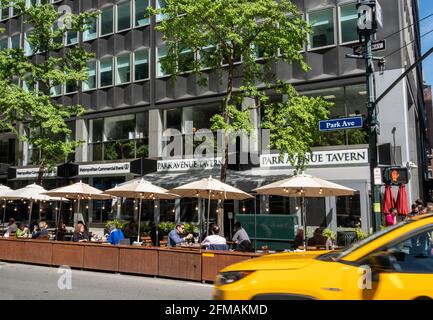 Park Avenue Tavern Diners godendo di un pomeriggio di sole a Murray Hill sotto gli ombrelloni sul marciapiede, New York, USA, 2021 Foto Stock