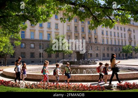 Gli studenti bulgari si svegliano davanti a una fontana in Piazza Atanas-Burov, oltre al Palazzo Presidenziale di Sofia, Bulgaria Foto Stock