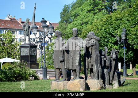 Scultura modernista nei giardini / piazza del Club militare, centro di Sofia, Bulgaria. Memoriale ai soldati ciechi di Samuel aka Tsar Samuil. Il Monumento dei volontari bulgari sullo sfondo. Foto Stock