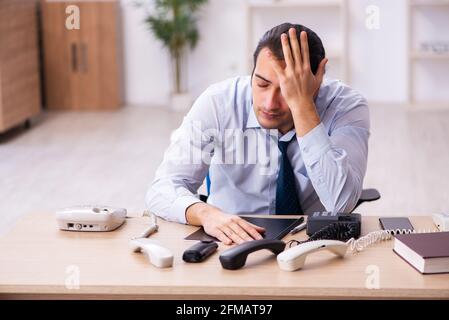 Giovane operatore del call center che lavora alla sua scrivania Foto Stock
