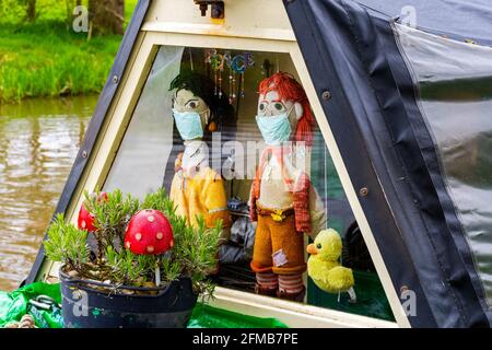 Due bambole in maglia con maschere facciali su un canale narrowboat, sul canale Llangollen (Shropshire Union) a Wrenbury, Cheshire, Inghilterra, Regno Unito Foto Stock