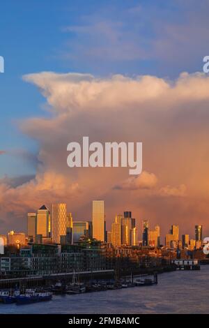 Inghilterra, Londra, Docklands, Fiume Tamigi e Canary Wharf Skyline con luce del tardo pomeriggio sulle nuvole di tempesta
