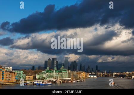 Inghilterra, Londra, Docklands, Fiume Tamigi e Canary Wharf Skyline con luce del tardo pomeriggio sulle spettacolari Nuvole delle tempeste