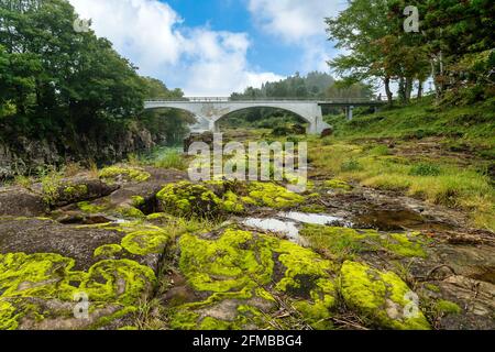 Una roccia con muschio verde e lotteria d'acqua la nebbia campagna mattutina dona un'atmosfera rinfrescante a Geibikei, una burrone nel fiume Satetsu a Ichi Foto Stock