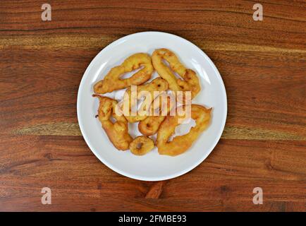 Piatto di calamari martoriati su un tavolo di legno Foto Stock