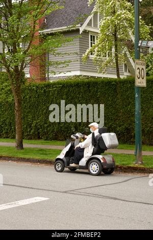 Uomo anziano che guida uno scooter elettrico a mobilità in una casa via Foto Stock