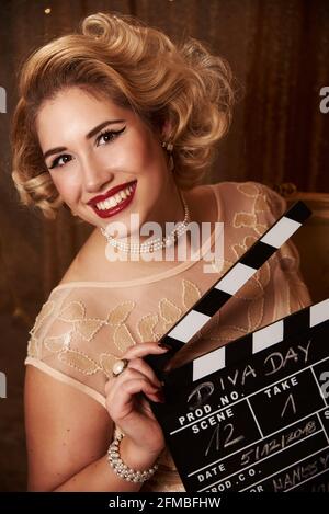 Giovane donna con capelli biondi Marilyn Monroe con clapperboard Foto Stock