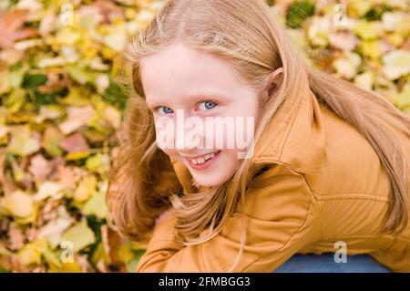 La ragazza sorride guardando la fotocamera, serie di ritratti bambino in autunno Foto Stock