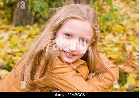 La ragazza sorride alla macchina fotografica, serie di ritratti bambino in autunno Foto Stock