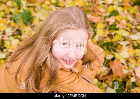 La ragazza sorride alla macchina fotografica, serie di ritratti bambino in autunno Foto Stock