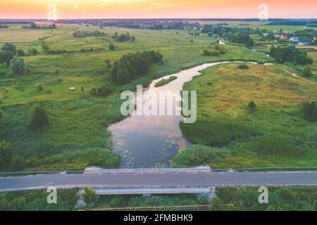 Vista dall'alto di un fiume in campagna in una giornata di sole. Paesaggio naturale con un bel cielo nuvoloso. In estate Foto Stock