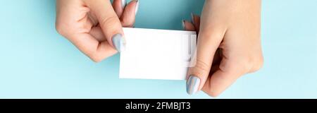 Mano della donna con manicure alla moda che tiene il biglietto da visita Foto Stock