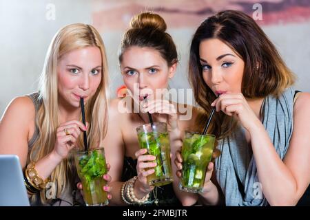 Giovani donne in bar o ristorante, di lavoro o di apprendimento insieme e divertirsi dopo l'orario di chiusura Foto Stock