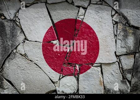 Bandiera nazionale del Giappone raffigurante in colori pittorici su un vecchio muro di pietra. Bandiera su sfondo muro rotto. Foto Stock