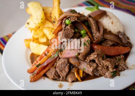 Lomo saltado è un piatto peruviano molto amato che è Un adattamento della cucina cinese con ingredienti peruviani Foto Stock