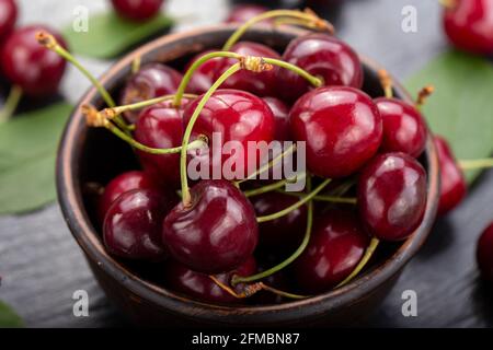 Ciliegie raccolte di fresco in una ciotola di argilla dal vostro giardino domestico. Concetto di cibo sano Foto Stock