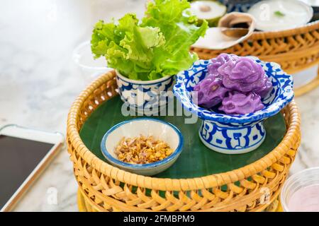 Il CHor Muang è un tradizionale dessert tailandese vintage a forma di fiori al vapore su un piatto antico nel piatto di vimini. Foto Stock