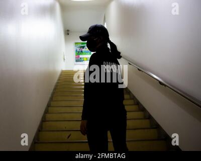 Una vista posteriore di una guardia di sicurezza femminile in uniforme pattugliamento in un edificio commerciale. Foto Stock