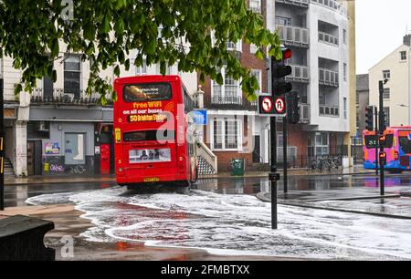 Brighton UK 8 maggio 2021 - UN autobus passa attraverso le acque alluvionali sulle strade intorno alla zona Valley Gardens di Brighton, come pioggia pesante passa attraverso la maggior parte delle parti della Gran Bretagna oggi, ma si prevede di riscaldarsi da domani nel Sud-Est : Credit Simon Dack / Alamy Live News Foto Stock