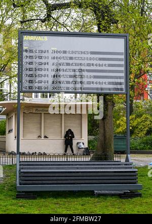 Brighton UK 8 maggio 2021 - UNA donna prende rifugio in Pavilion Gardens Brighton come pioggia pesante passa attraverso la maggior parte delle parti della Gran Bretagna oggi, ma si prevede di riscaldarsi da domani nel Sud-est: Credit Simon Dack / Alamy Live News Foto Stock