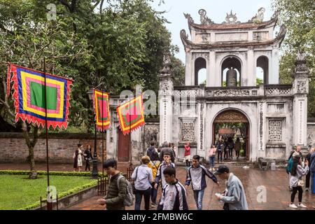 Campanile e ingresso, Tempio Confuciano, Văn Miếu, noto anche come Tempio della Letteratura, con 5 bandiere elementi, Hanoi, Vietnam Foto Stock