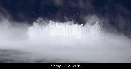 BANNER astratto. Vera nube di fumo Mystic con gocce d'acqua che esplodono, movimento di volo a vapore, sfondo scuro. Esperimento chimico, aromaterapia, bevanda bruciata Foto Stock