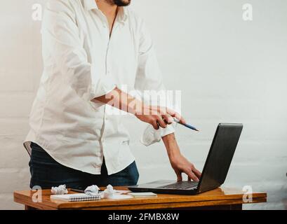 Primo piano di un uomo caucasico bianco che punta la sua penna sullo schermo del computer portatile Foto Stock