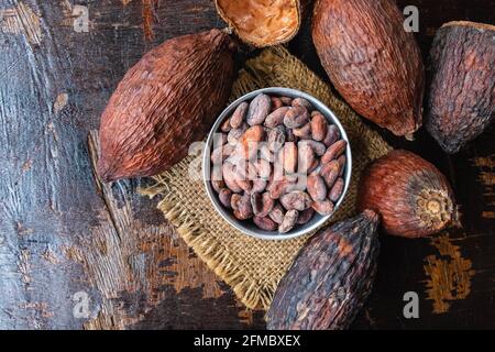 Frutta secca di cacao e fagioli di cacao in un recipiente sopra il tavolo Foto Stock