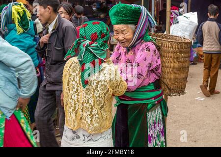 Mercato etnico minoritario di Dong Van, donne H'mong con paniere sul retro, provincia di ha Giang, Vietnam del Nord Foto Stock