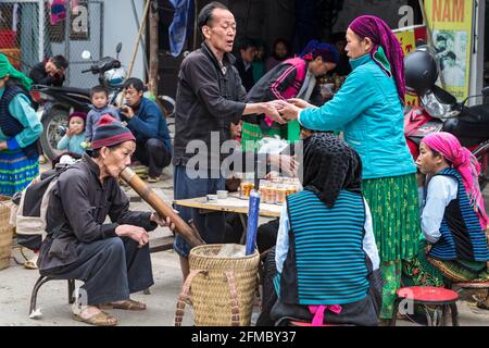 Fumo di pipe, Thuoc Lao, via tubo di acqua di bambù, dieu cay, + vino di mais bevente, metà mattina, mercato di minoranza etnica di Dong Van, principalmente H'mong, ha Giang Foto Stock