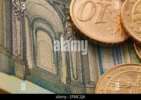 Serie di macro shot di monete in euro. Primo piano di 100 euro di bolletta con alcune monete su di esso come sfondo Foto Stock