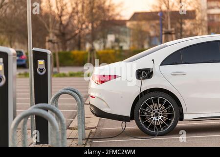 Un'auto completamente elettrica presso una stazione di ricarica Foto Stock