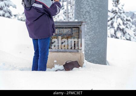 Cablaggio scatola di collegamento telefono, tecnico in piedi nella neve e riparare la linea telefonica. Foto Stock