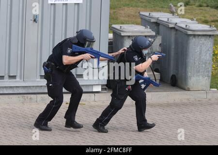 Weimar, Germania. 8 maggio 2021. Gli agenti di polizia con caschi e mitragliatrici corrono su un campo di allenamento durante un esercizio di controllo di disastri. Oltre agli agenti di polizia, al servizio di soccorso e al reparto vigili del fuoco, è stato dispiegato l'intero plotone medico e di supporto della città di Weimar. Una situazione di amok in un allenatore è stata assunta. Credit: Bodo Schackow/dpa-Zentralbild/ZB/dpa/Alamy Live News Foto Stock