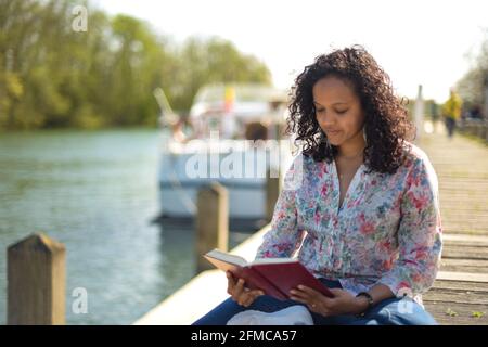 metis donna che legge in natura Foto Stock