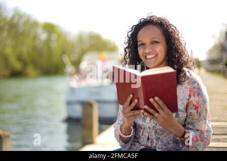 metis donna che legge in natura Foto Stock