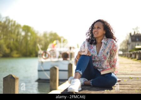 metis donna che legge in natura Foto Stock