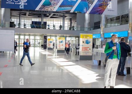 Mosca, Russia - 14 aprile 2021 : la gente cammina nella hall del centro espositivo Crocus Expo di fronte all'ingresso della mostra Foto Stock